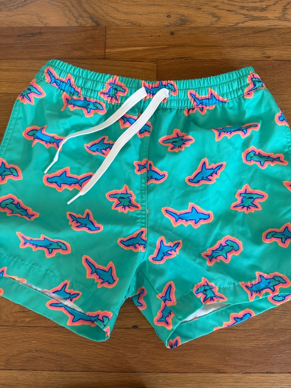 chubbies Kids Swim Trunks in Turquoise with Pink-Outlined Blue Sharks